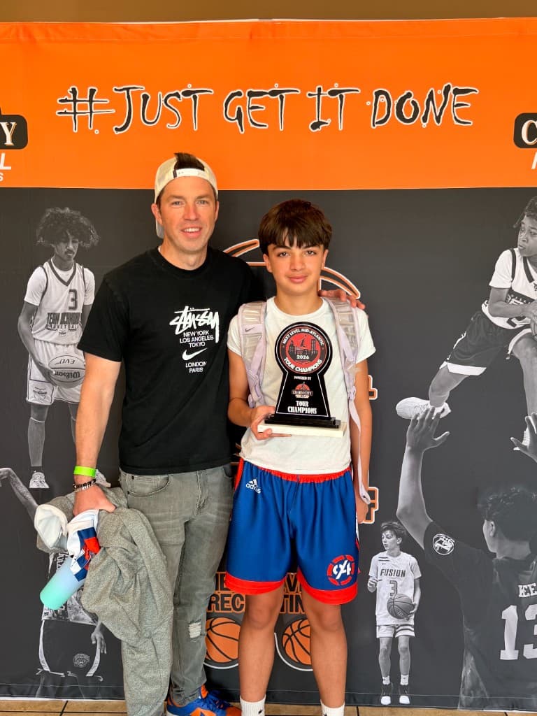 Brian Hoffman, StatHoops founder and AAU coach, with his son and a tournament championship trophy